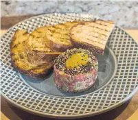  ??  ?? Two of the small dishes that are available at Omai Restaurant in Baldwin Village: crudo, at top, as well as steak tartare.