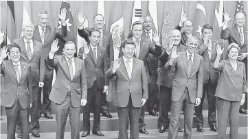  ??  ?? Obama (second right) waves with other world leaders as they take part in the G20 ‘family photo’ during the G20 Summit in Brisbane. — AFP photo