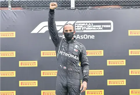  ?? AFP ?? Mercedes’ Lewis Hamilton raises his fist on the podium after winning the Styrian Grand Prix.