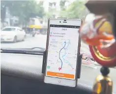  ??  ?? This file picture shows a taxi driver using the Didi Chuxing app while driving along a street in Guilin, in China’s southern Guangxi region. China has ordered the suspension of carpool services offered by ride-hailing firms until tighter safety measures are implemente­d, seeking to ease fears after two users of sector leader Didi Chuxing’s Hitch service were murdered. — AFP photo