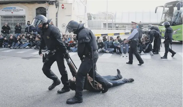  ?? PICTURE: PAU BARRENA/GETTY ?? 0 Catalan regional policemen – Mossos d’esquadra – drag away a picket as strikers blocked access to a bus station in northern Barcelona