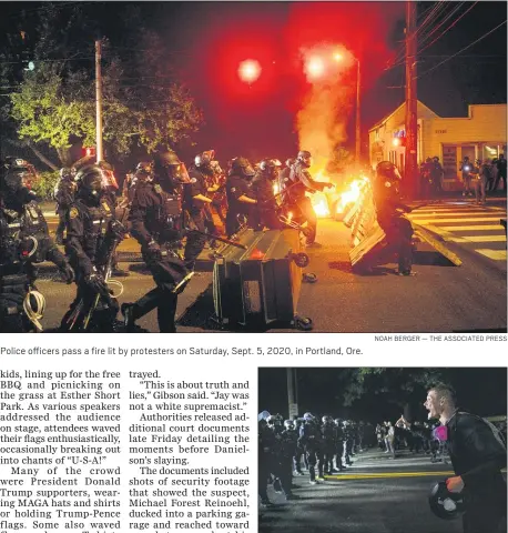  ?? NOAH BERGER — THE ASSOCIATED PRESS ?? Police officers pass a fire lit by protesters on Saturday, Sept. 5, 2020, in Portland, Ore.