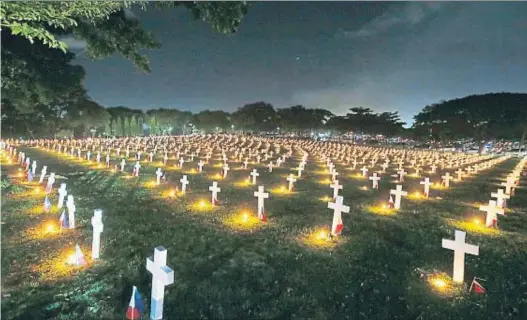  ?? BULLIT MARQUEZ / AP ?? Per la pàtria. Tombes il·luminades amb espelmes al Cementiri dels Herois de Manila, amb motiu de la
festivitat de Tots Sants