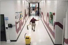  ?? John Moore / Getty Images ?? A custodian cleans ahead of the return of students for the upcoming semester at APPLES Pre-K School on Aug. 26 in Stamford.