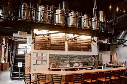  ?? Photos by Steve Barnes/times Union ?? The bar at Common Roots Brewing Co. Albany Outpost, which has taken over the former Albany Pump Station building at Quackenbus­h Square downtown, has 24 draft lines. One or two are dedicated to pouring Pump Station beers that Common Roots agreed to continue brewing. Between taps, bottles and cans, at least 30 Common Roots beers should be available most of the time. The brewpub has a full liquor license, but its limited spirits selection includes only those made in New York.