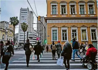  ?? Daniel Marenco/FolhaPress ?? Pessoas caminham em rua de Porto Alegre, no Rio Grande do Sul