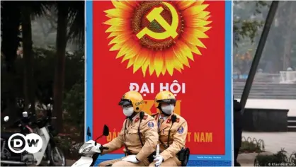  ??  ?? Police officers patrol near a poster in Hanoi for the 13th national congress of the Communist Party of Vietnam