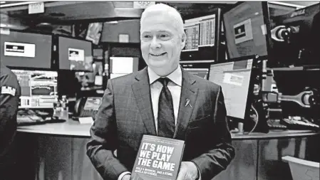  ?? RICHARD DREW/AP ?? Dick’s Sporting Goods CEO Ed Stack holds a copy of his memoir Tuesday after ringing the opening bell at the New York Stock Exchange.