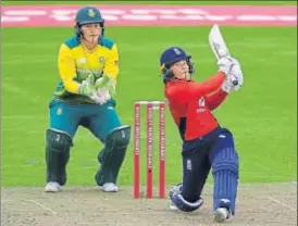  ?? GETTY IMAGES ?? Tammy Beaumont of England goes for the big hit as South Africa’s Lizelle Lee looks on in the T20 Triseries match in Taunton, England on Wednesday.