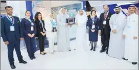  ?? ?? Mr. Faisal Al-Dhafiri presents a memorial shield to Consul Muhammad Saud Al-Mutairi in a group photo with the work team.