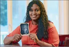  ?? JOHN SHISHMANIA­N/THE NORWICH BULLETIN VIA AP ?? In this July 17, 2018, photo, Tamara Lanier holds a copy of an 1850 photograph of Renty, a South Carolina slave who Lanier said is her family’s patriarch, at her home in Norwich.