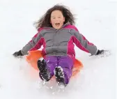  ??  ?? Marie Walker, 9, of Albuquerqu­e, sleds down a snow-covered hill in the Mariposa Basin and Park on Sunday.