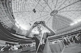  ?? Gary Coronado / Houston Chronicle ?? Rebecca Smith, of Conroe, videos the inside of the Astrodome during the 50th anniversar­y of the opening of the stadium last April. Two Rice graduates say the Dome could be the backdrop for a light show by next year’s Super Bowl.