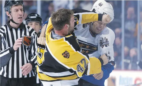  ?? DOUG PENSINGER / GETTY IMAGES FILES ?? P.J. Stock, left, of the Boston Bruins throws a punch at Stephen Peat of the Washington Capitals in one of the many scuffles in Peat’s short NHL career.