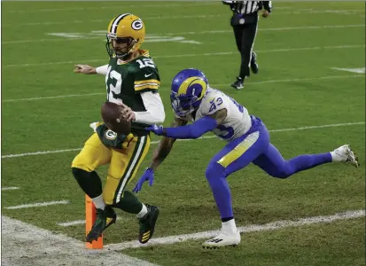  ?? MATT LUDTKE — THE ASSOCIATED PRESS ?? Green Bay Packers quarterbac­k and Chico native Aaron Rodgers scores on a 1-yard touchdown run past the Los Angeles Rams’ John Johnson during the first half of a divisional playoff game Saturday in Green Bay, Wis.