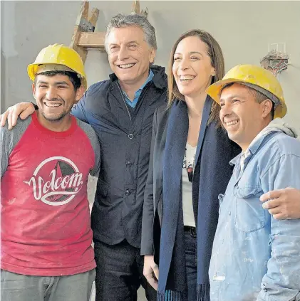  ??  ?? Sonrisas. Mauricio Macri y María Eugenia Vidal, ayer en Florencio varela, junto a dos trabajador­es.