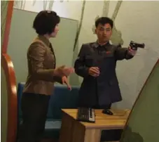  ??  ?? A staff member coaches a North Korean man at a high-tech shooting range. It is one of the more popular tourist sites in Pyongyang.