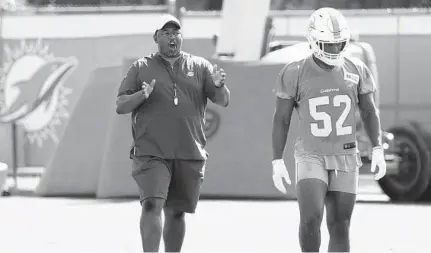  ?? LYNNE SLADKY/AP ?? Defensive coordinato­r Patrick Graham talks with linebacker Raekwon McMillan on July 26 in Davie, Fla. McMillan missed the entire preseason.