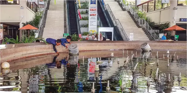  ?? FAJRIN MARHAENDRA BAKTI/JAWA POS ?? GRATISAN: M. Asul (kiri) sibuk mencari ikan di kolam Anjungan Terminal I Bandara Juanda kemarin (4/2). Ikan hasil tangkapan dibawa pulang ke Lamongan untuk kenang-kenangan.