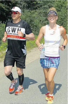  ?? RICK KENT/ ULTRAMAN CANADA ?? Michael Brown running with his sister-in-law, Amy Downing (above) and riding in the gruelling 420-kilometre bicycle leg of the race.