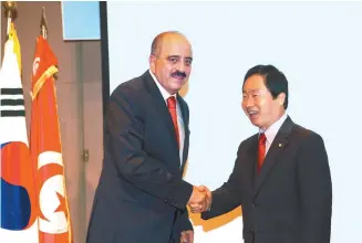  ?? Courtesy of Embassy of Tunisia ?? Tunisian Ambassador to Korea Mohamed Ali Nafti, left, shakes hands with Korea-Tunisia Parliament­ary Friendship Group President Joo Gwang-deok during a reception that marked Tunisia’s 60th National Day at the Korea Press Center in Seoul, July 25.