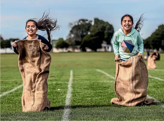  ?? PHOTO: ANDY JACKSON/STUFF ?? Sisters Tekaapuara­ngi, 7, left, and Ashlee Rose Murphy, 10, take each other on in a sack race.