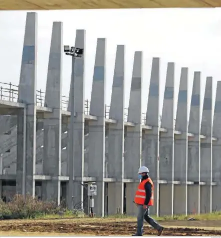  ?? REPORTAJE FOTOGRÁFIC­O: JAVIER ALBIÑANA ?? Un operario de Hermanos Campano camina por los terrenos de Arraijanal con la estructura del campo de fútbol al fondo.