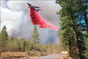  ??  ?? The Associated Press
A tanker drops retardant over the Mitchell Monument area in Oregon on Saturday.