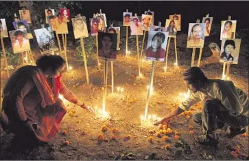  ?? Ajit Solanki Associated Press ?? A 2012 candleligh­t vigil in Ahmadabad, India, with victims’ portraits marks the 10th anniverary of the Gujarat riots. Many Muslims in Gujarat still associate Prime Minister Narendra Modi with religious persecutio­n.