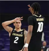  ?? LINDSEY WASSON — THE ASSOCIATED PRESS ?? Colorado guard KJ Simpson, left, and forward Cody Williams gesture after Williams made a 3-pointer at Washington on Jan. 24.