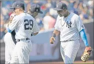  ?? KATHY WILLENS — THE ASSOCIATED PRESS ?? Yankees third baseman Gio Urshela (29) embraces relief pitcher Aroldis Chapman as they celebrate with first baseman Chris Gittens, after turning a game-ending triple-play to defeat the A’s.