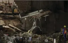  ??  ?? Rescue workers use a crane to lift a section of concrete floor as they remove rubble in hopes of reaching dozens of people believed to be trapped inside a collapsed office building since a 7.1 magnitude earthquake, in the Roma Norte neighborho­od of...