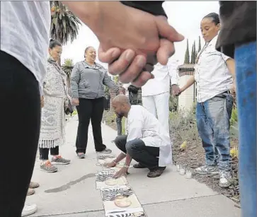  ?? Photog raphs by Francine Orr Los Angeles Times ?? NANA LAWSON, middle, joins other protesters from the Black Lives Matter movement in prayer Sunday on the sidewalk outside Getty House, the official mayoral residence in Windsor Square.