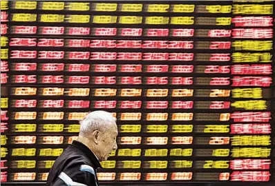  ??  ?? An investor walks past an electronic board showing stock informatio­n at a brokerage house in Shanghai. The Shanghai Composite Index has declined by about 20 percent so far this year and is already the worst performer among the major stock indexes in the world. Shanghai