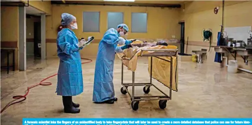  ??  ?? A forensic scientist inks the fingers of an unidentifi­ed body to take fingerprin­ts that will later be used to create a more detailed database that police can use for future identifica­tion or relatives can search to find a loved one, on March 3, 2019 at the Johannesbu­rg Morgue. — AFP