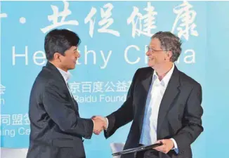  ?? STR AGENCE FRANCE-PRESSE ?? Le p.-d.g. de Baidu, Robin Li, aux côtés de l’actuel directeur de Microsoft, Bill Gates, en 2011