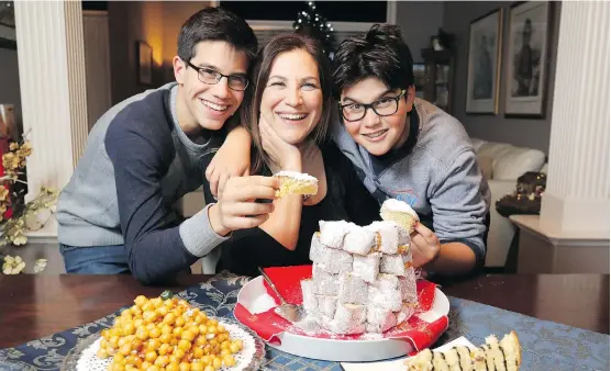  ?? DARREN MAKOWICHUK ?? Anna Marchisano Marinzi, chef and owner of Pizza on the Fly, and sons Marco, left, and Tommaso enjoy some of her Italian Christmas food at their Calgary home.