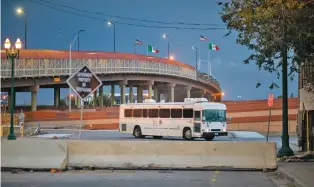  ?? PHOTOS BY IVAN PIERRE AGUIRRE/FOR THE NEW MEXICAN ?? A bus leaves an immigratio­n processing center earlier this month near the Paso del Norte Internatio­nal Bridge between El Paso and Ciudad Juárez, Mexico. A bus or van often takes migrants from the bridge to the local federal courthouse for hearings.