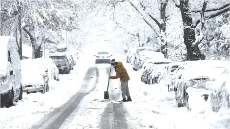  ?? — AFP photo ?? A person shovels snow during a snow storm in New York City. The region around New York is experienci­ng its second major snow storm in a week with up to 8 inches expected in the city and outlying areas.