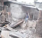  ?? ODELYN JOSEPH/AP ?? A man shows on Friday how his home was set on fire during clashes between gangs in Haiti’s capital.