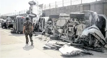  ?? SAIFURAHMA­N SAFI Xinhua/Sipa USA ?? A Taliban member passes damaged vehicles at the Kabul airport on Sept. 20, 2021, less than a month after the U.S. withdrawal. A new review of the August 2021 attack on the airport supported the findings of a previous investigat­ion.