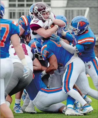  ?? DANA JENSEN/THE DAY ?? Springfiel­d College’s Tim Callahan (49) is stopped by the Coast Guard Academy’s defense during Saturday’s NEWMAC game in New London. Springfiel­d held on to beat the Bears 20-14.