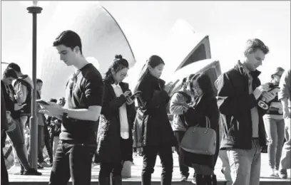  ?? AFP ?? People play PokemonGo outside the Sydney Opera House. The game created a global frenzy as players roam the streets looking for virtual monsters.