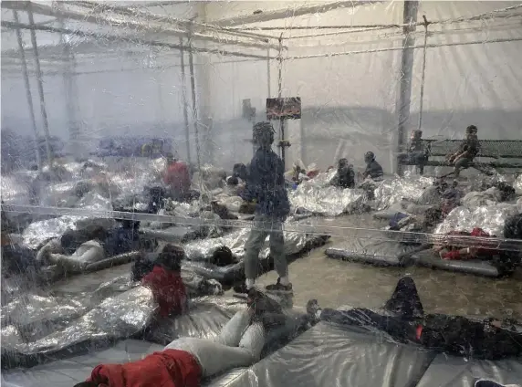  ?? Ap ?? KEPT: Detainees in a Customs and Border Protection temporary overflow facility are shown in Donna, Texas.