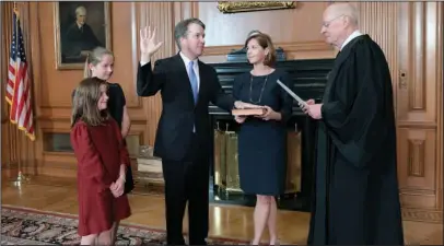  ?? The Associated Press ?? JUDICIAL OATH: Retired Justice Anthony M. Kennedy, right, administer­s the Judicial Oath to Judge Brett Kavanaugh on Friday in the Justices’ Conference Room of the Supreme Court Building. Ashley Kavanaugh holds the Bible. At left are their daughters, Margaret, background, and Liza.