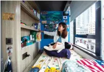  ??  ?? Jezz Ng sits on her bed where she rents a small living space in a co-sharing building in the Mong Kok district.