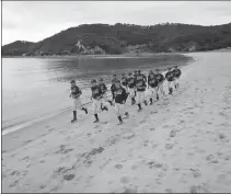  ?? REUTERS ?? Members of the Deokjeok High School baseball team run on a beach during a practice session on Deokjeok island.