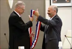  ?? (Photos P. Bl.) ?? C’est le communiste Michel Camatte, doyen du conseil municipal (à droite) qui a présidé la séance d’installati­on. Il a remis à Jean-Louis Masson son écharpe tricolore.