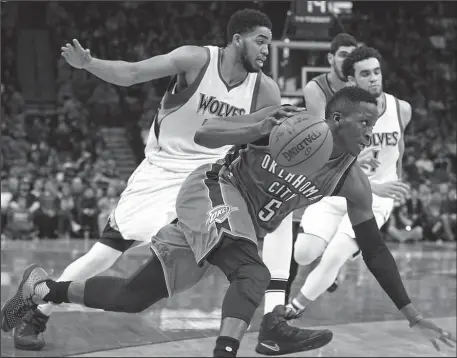  ?? The Associated Press ?? DRIVING LANE: Oklahoma City Thunder guard Victor Oladipo drives past Minnesota Timberwolv­es’ Karl-Anthony Towns, left, during the second half of an NBA basketball game Tuesday in Minneapoli­s. The Thunder won 100-98.