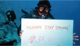  ?? by Asim Mohamed/xinhua ?? February 5: A local diver cheers for China’s Wuhan at Maafushi’s Cocoa Reef, Maldives.